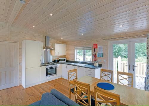 a kitchen and dining room with a table and chairs at Dovestone Luxury Lodges sleeps 4 - pets welcome in Oldham