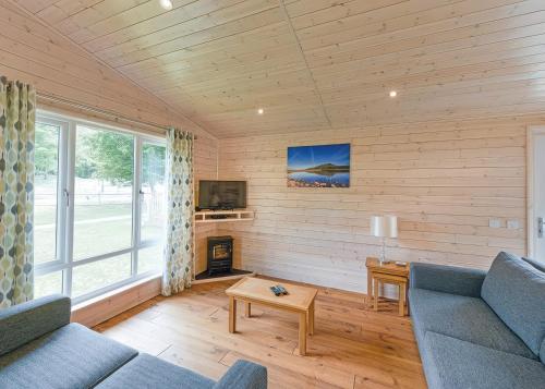 a living room with a couch and a table at Dovestone Luxury Lodges sleeps 4 - pets welcome in Oldham
