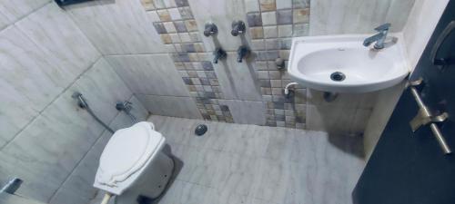 a bathroom with a toilet and a sink at Arihant palace in Shirdi