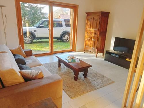 Chalet luxueux avec piscine intérieure في لابريس: غرفة معيشة مع أريكة وطاولة قهوة