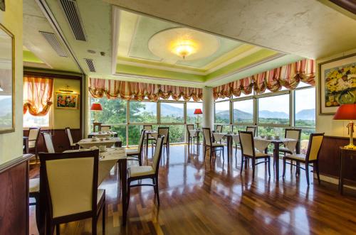 a dining room with tables and chairs and windows at Hotel Ovidius in Sulmona