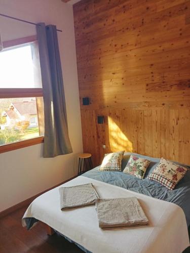 - une chambre avec un lit et un mur en bois dans l'établissement Chalet luxueux avec piscine intérieure, à La Bresse
