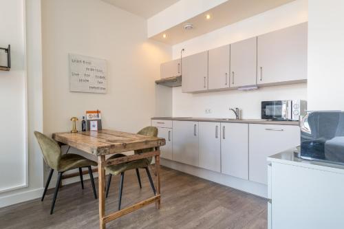 a kitchen with a wooden table and chairs at Hotel Oranjestaete in Nijmegen