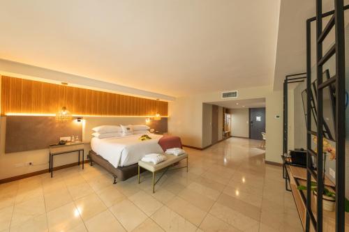 a large bedroom with a bed and a desk and a couch at Hotel El Panama by Faranda Grand, a member of Radisson Individuals in Panama City