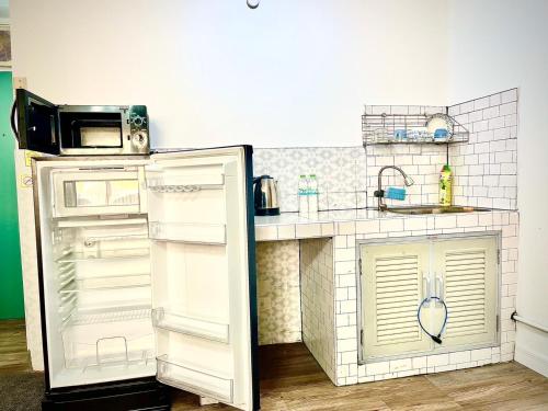 a small kitchen with a refrigerator and a sink at Impact Arena Condo C3 by GoodRoom24 in Ban Bang Phang