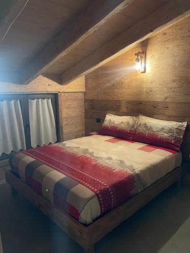 a bedroom with a large bed with a wooden headboard at Sabbionaccio Apartments & Spa in Chiesa in Valmalenco