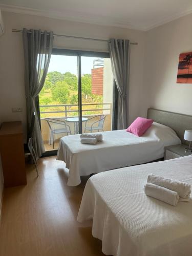 ein Hotelzimmer mit zwei Betten und Balkon in der Unterkunft Jardins da guia in Albufeira