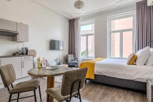 a hotel room with a bed and a table and a kitchen at Hotel Oranjestaete in Nijmegen