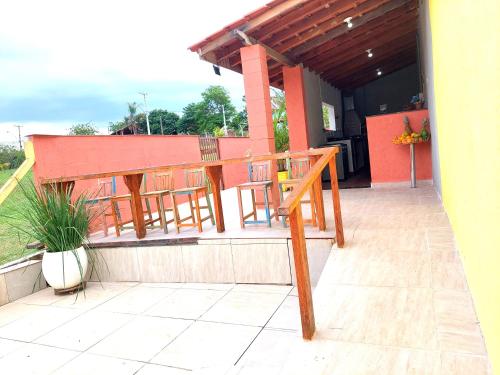 a porch with a wooden table and chairs on it at Temporada Belas Casas in São Pedro