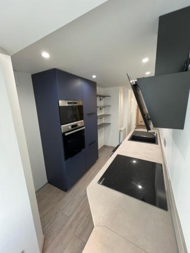 Il comprend une cuisine équipée d'une cuisinière et d'une armoire bleue. dans l'établissement Appartement RDC 2-4 pers proche plage, à Quiberon