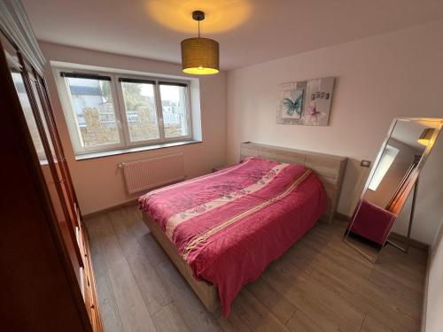 - une chambre avec un lit rose et une fenêtre dans l'établissement Appartement RDC 2-4 pers proche plage, à Quiberon
