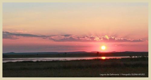 a sunset over a river with the sun in the sky at Mirador El Silo in Bello