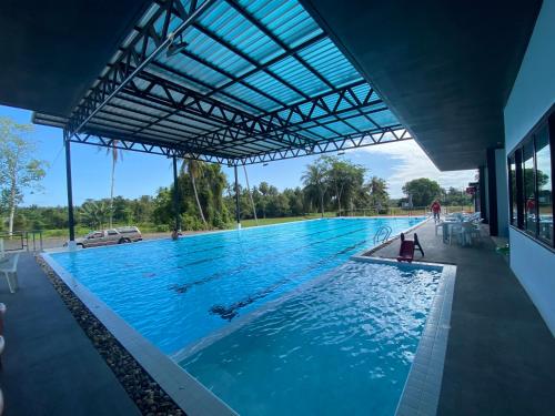 una grande piscina con una persona in acqua di Marine Resort มารีน รีสอร์ต a Ban Hin Sam Kon