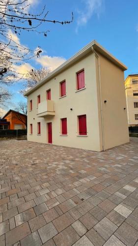 a large white building with red windows on it at Casa Laguna Escape in Mestre
