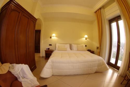 a bedroom with a white bed and a large window at Resort Santangelo & SPA in Pimonte