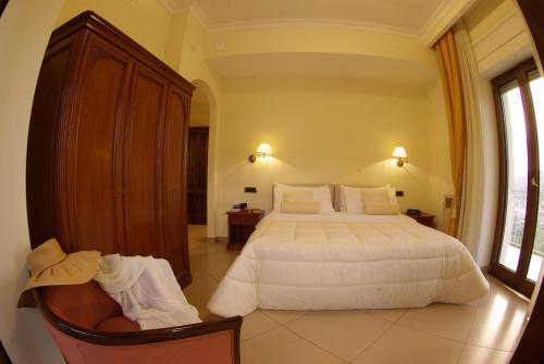 a bedroom with a large white bed and a window at Resort Santangelo & SPA in Pimonte
