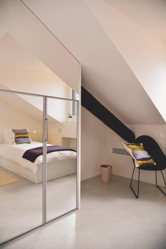 1 dormitorio en el ático con 1 cama y 1 silla en One Only Nassa Penthouse with large private terrace, en Lugano