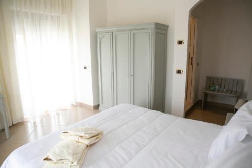 a white bed with a robe on it in a bedroom at Resort Santangelo & SPA in Pimonte