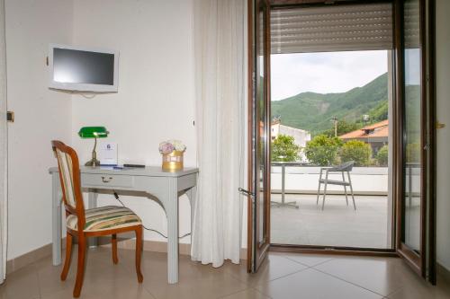 a desk and chair in a room with a balcony at Resort Santangelo & SPA in Pimonte