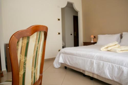 a bedroom with a white bed and a chair at Resort Santangelo & SPA in Pimonte