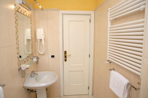 a white bathroom with a sink and a mirror at Resort Santangelo & SPA in Pimonte