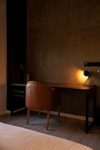 a chair sitting in front of a desk with a lamp at VAUX Park Street Hotel - A collection of 8 luxury lofts in Colombo