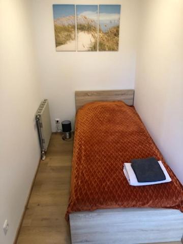 a bedroom with a bed with a orange comforter at APARTMENT Top 11 ZENTRUM mit 2 Schlafzimmer BESTROOMS eU in Steyr