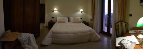 a bedroom with a bed with a white comforter at Resort Santangelo & SPA in Pimonte