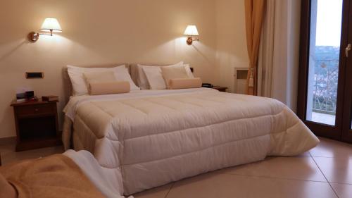 a large white bed in a room with a window at Resort Santangelo & SPA in Pimonte
