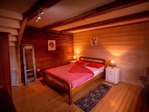 a bedroom with a bed in a room with wooden walls at Wooden veggie house Koliba near Plitvice Lakes in Plaški