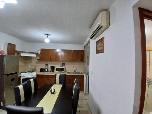 a kitchen with a table and chairs and a refrigerator at Departamento bonito en Huatulco in Santa Cruz Huatulco