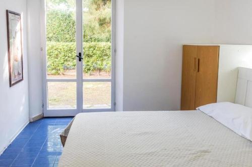 a bedroom with a bed and a large window at M080 - Marcelli, residence Mare Verde trilo con giardino in Marcelli