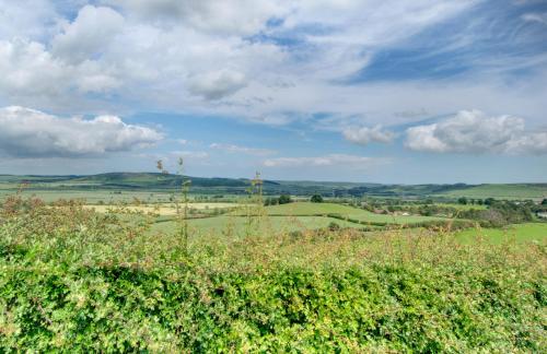 a field of green grass with a blue sky and clouds at Braeside in Wooler