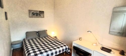 - une petite chambre avec un lit et une lampe dans l'établissement Le Turenne, T2 cozy et calme, wifi, tv, stationnement aisé, à Tours