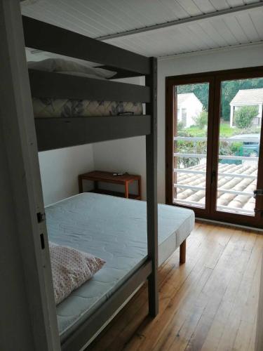 - une chambre avec 2 lits superposés et un balcon dans l'établissement Maison bord de mer climatisée en Corse, à Poggio-Mezzana