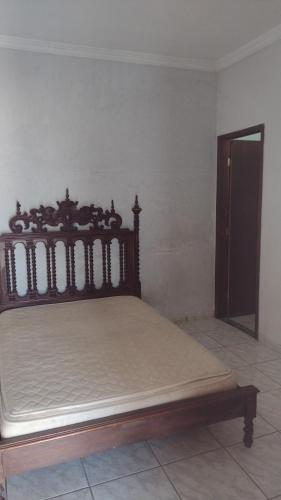 a bedroom with a wooden bed in a room at Sítio do sucego in São Gonçalo do Pará