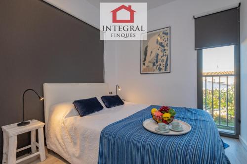 een slaapkamer met een bed met een fruitschaal op een tafel bij L'Àtic de Palamós in Palamós