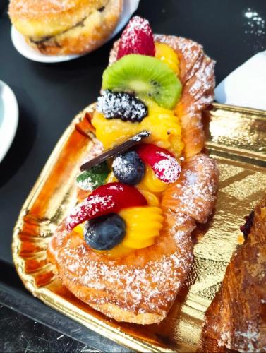 a plate of food with fruit on top of toast at Locazione turistica Giulia in Fiumicino