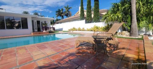 a patio with a table and chairs next to a swimming pool at The views rental house in Pompano Beach