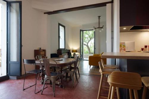 a dining room with a table and chairs at JARDIN & VUE MER Maison des années 20 proche du centre historique in Grasse