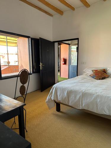 a bedroom with a bed and a table and a window at atlas lodge in Amizmiz