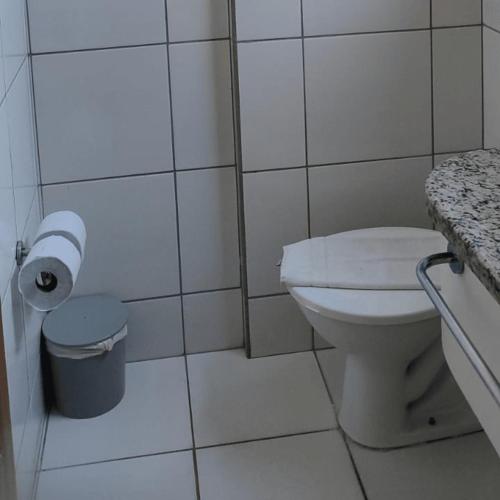 a bathroom with a toilet and a roll of toilet paper at Golden Dolphin Grand Hotel piscinas 24 hs MP in Caldas Novas