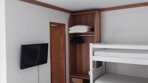 a room with a bunk bed and a television at Golden Dolphin Grand Hotel piscinas 24 hs MP in Caldas Novas