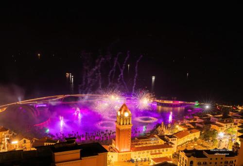 a city with a fountain and a clock tower at night at Luna Sol Villas - Dedicated Care Until Check Out in Phu Quoc