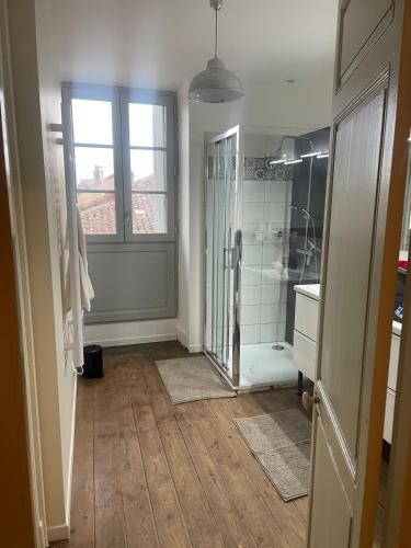 une salle de bain avec douche et porte vitrée dans l'établissement Chez François, à Masseube