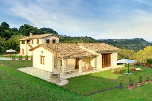 a small white house with a yard with a lawn sidx sidx sidx at Relais Borgo Gentile in Tarano