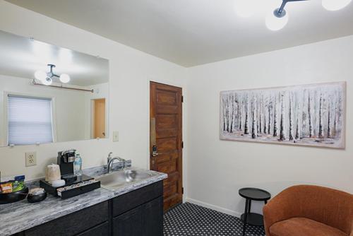 a kitchen with a sink and a mirror and a chair at Daniell Manor in Laurium