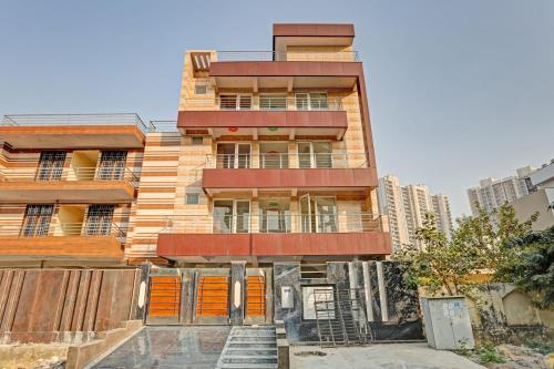Un edificio de apartamentos con puertas naranjas en una ciudad. en Hotel O Mango Bloom, en Noida