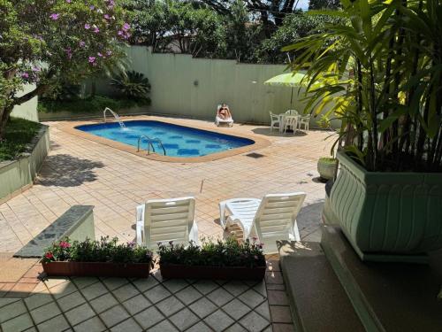 a patio with chairs and a swimming pool at Mansão Adalgisa in Osasco