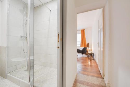 a bathroom with a shower and a glass door at Appartement Place Stanislas 2 in Nancy